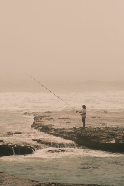 Angler casting a metal jig from a rock platform