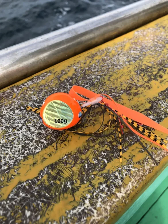 Orange tairaba head and skirt resting on the boat gunwale