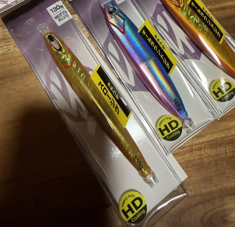 Three Japanese metal jigs in their retail packages, with labels printed in Japanese and weights in grams